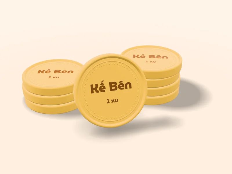Chồng xu đất sét màu vàng mật ong, đồng xu giữa đứng thẳng in chữ Kế Bên và 1 xu — mặt xu hạng Vàng