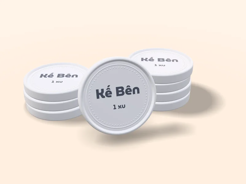 Chồng xu đất sét màu bạc xám nhạt, đồng xu giữa đứng thẳng in chữ Kế Bên và 1 xu — mặt xu hạng Bạc